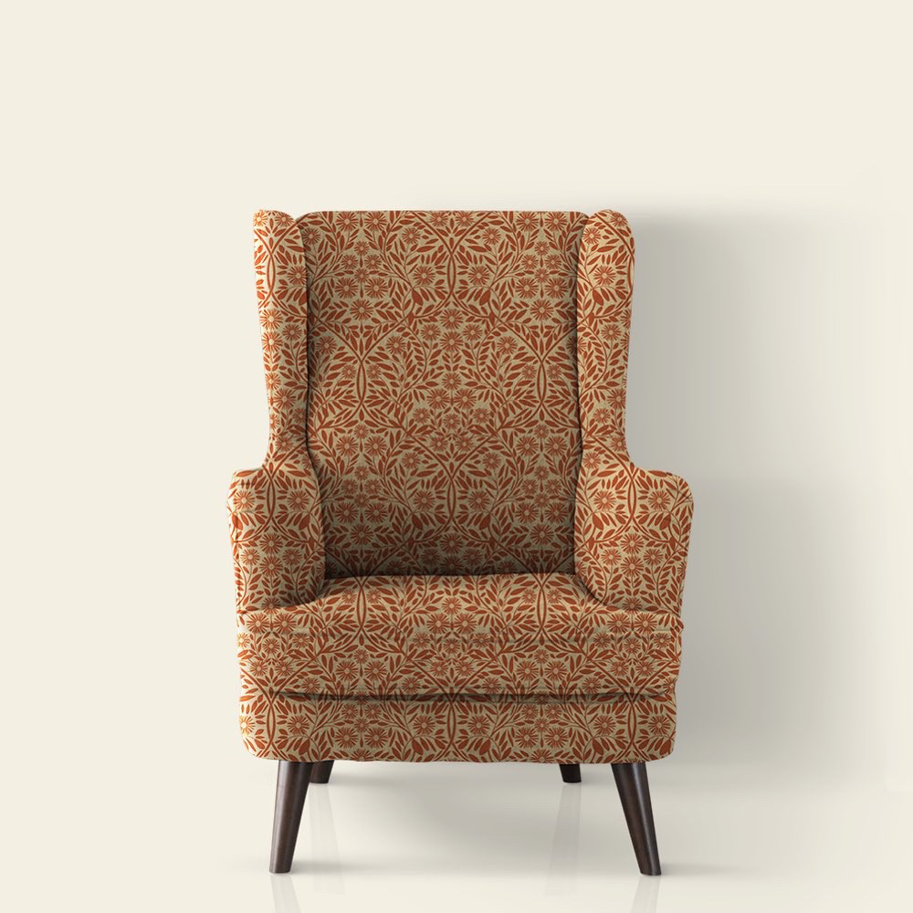 A high back armchair upholstered in a cream and dark orange fabric inspired by the Arts and Crafts movement called Michaelmas Daisy Michaelmas Daisy (Two Colour - Orange on Cream).
